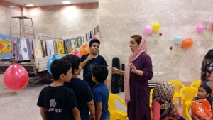 یک مربی در حال صحبت با بچه‌ها درباره فعالیت‌های مرتبط با کتاب / با من بخوان در بنیاد کودک - شهریور 94