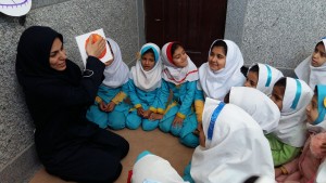 A tutor reads aloud with children - Read with Me in Zahedan - Jan 2016