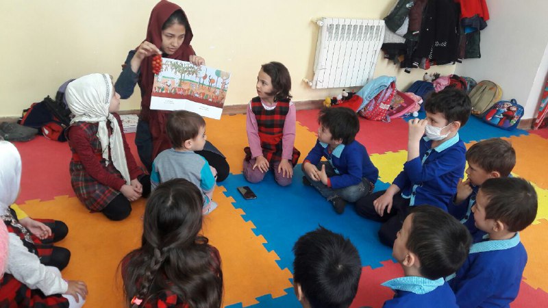 A tutor reads aloud with children - Read with Me in MahmoodAbad