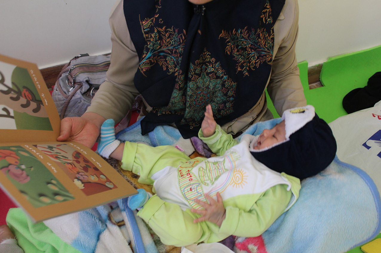 A Mother reading with her baby in babies and toddlers workshop - Read with Me in MahmoodAbad